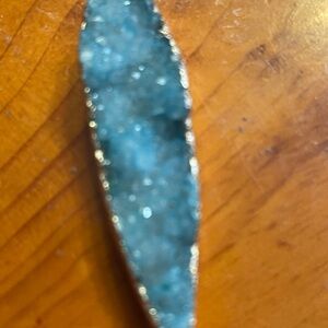 Pendant: druzy of a turquoise stone set in gold. 2" x 1/2". Smoke free.